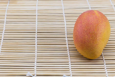 mango on bamboo brown straw mat for backgroundの写真素材