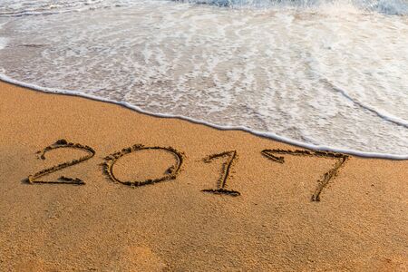 New Year 2017 is coming concept - write  2017 on a beach sandの写真素材