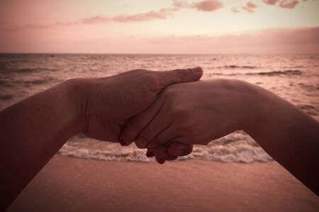 Vintage girls holding hands backdrop of the sea