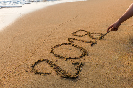 Write 2018  on a beach sand  background