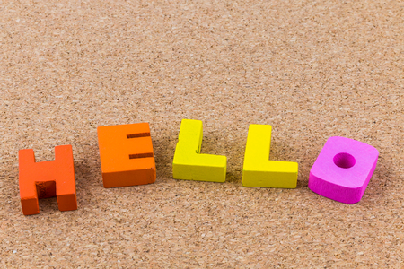 Colorful wooden English alphabets hello on brown cork wood  backgroundの写真素材