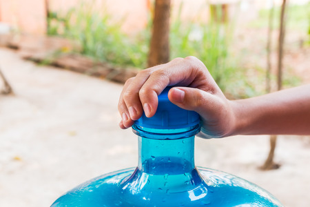 Girl hands with a large mineral water containeの写真素材