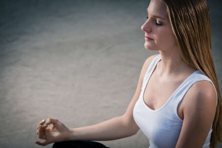 Young woman 20-25 sitting and meditating environment yoga meditation in a modern, warm, outdoorの写真素材