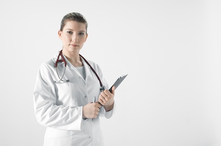 Young female doctor in white room with boardの写真素材