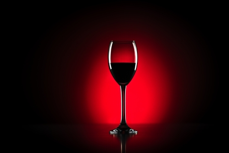 Red wine glass in studio with red backgroundの写真素材