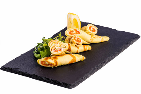 Rolls of thin pancakes with smoked salmonon stoneの写真素材