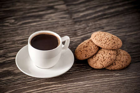 cup of coffee with oatmeal cookies on a wooden table