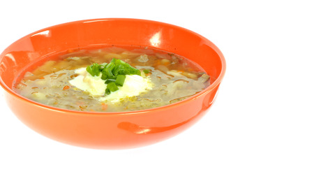 Orange bowl of soup with cabbage on a white background melted sour creamの写真素材
