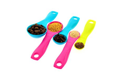 Various spices and grains on color measuring spoons white backgroundの写真素材