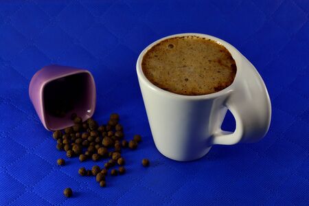 Cup of coffee with milk and spice seeds grains on a blue backgroundの写真素材