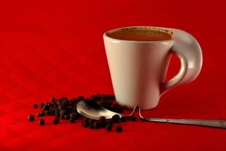 Cup of coffee with milk and spice seeds grains on a red backgroundの写真素材