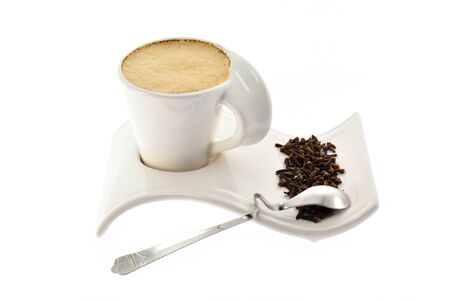 Cup of coffee with milk on a beautiful stand of grain seeds and spices on a white backgroundの写真素材