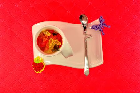 White cup on a beautiful stand with marmalade on a red backgroundの写真素材