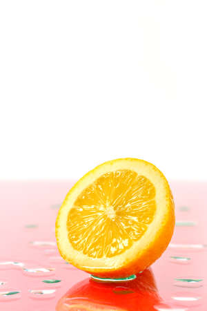 Sliced half of a ripe lemon and water drops on glassの写真素材