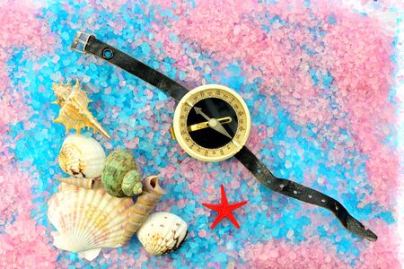 Shells, star and tourist compass on sea salt in different colorsの写真素材