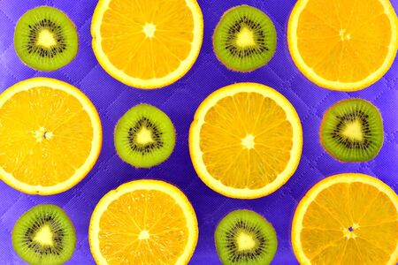 lilac background of the different types of citrus orange, lemon, grapefruit and kiwiの写真素材