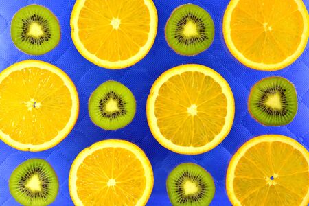 The blue background of the different types of citrus orange, lemon, grapefruit and kiwiの写真素材