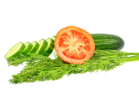 Sliced cucumber into slices next half tomato and dill on a white backgroundの写真素材