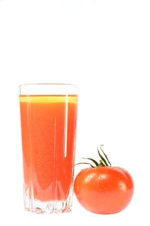 Red tomato and a glass of tomato juice on a white backgroundの写真素材