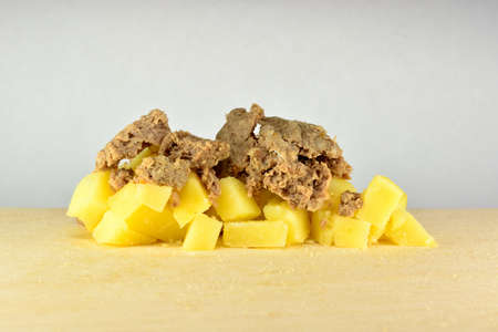 Boiled meat and potatoes diced on the tableの写真素材