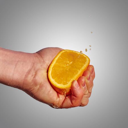 Squeezing an orangeの写真素材