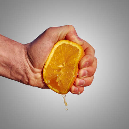 Squeezing an orangeの写真素材