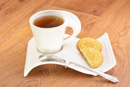 Black tea in a white mug and cookies on a wooden backgroundの写真素材