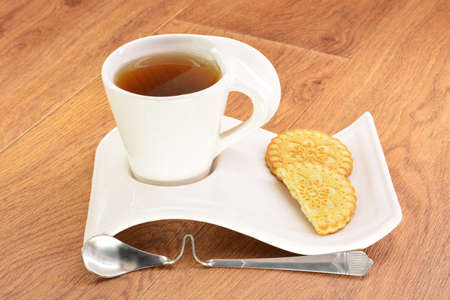 Black tea in a white mug and cookies on a wooden backgroundの写真素材