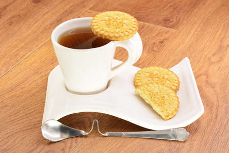 Black tea in a white mug and cookies on a wooden backgroundの写真素材