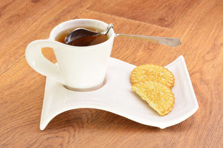 Black tea in a white mug and cookies on a wooden backgroundの写真素材