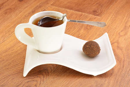 Black tea in a white mug and cake on a wooden backgroundの写真素材