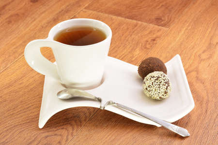 Black tea in a white mug and cake on a wooden backgroundの写真素材