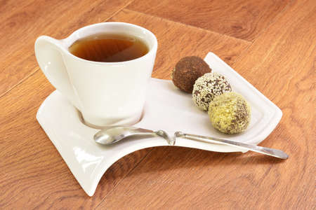 Black tea in a white mug and cake on a wooden backgroundの写真素材