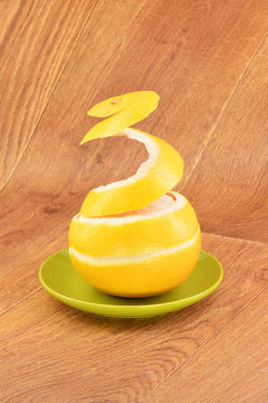 Ripe grapefruit in a green plate on a wooden backgroundの写真素材