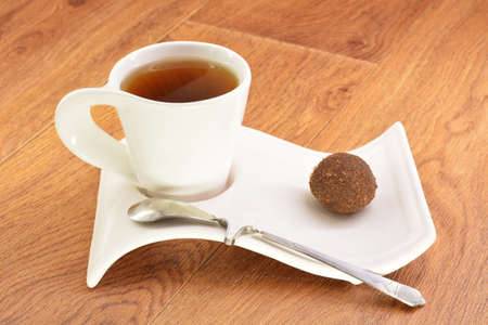 Black tea in a white mug and cake on a wooden backgroundの写真素材
