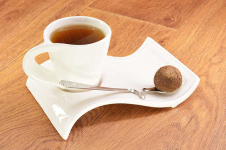 Black tea in a white mug and cake on a wooden backgroundの写真素材