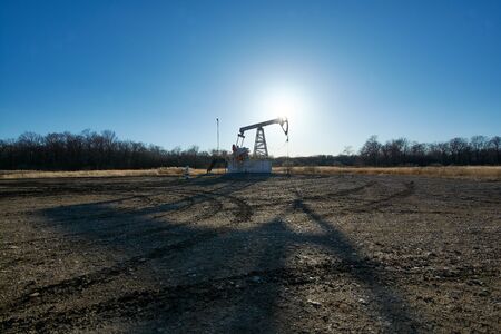 Oil rig in the field at sunsetの写真素材