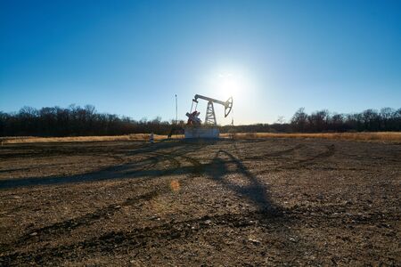 Oil rig in the field at sunsetの写真素材