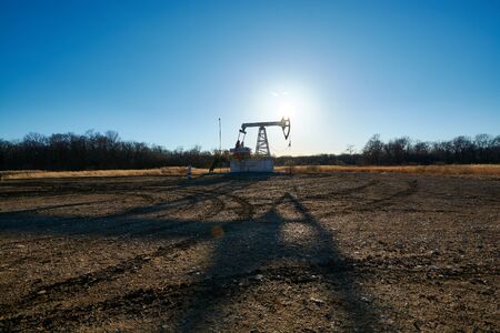 Oil rig in the field at sunsetの写真素材