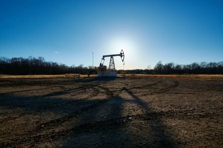 Oil rig in the field at sunsetの写真素材