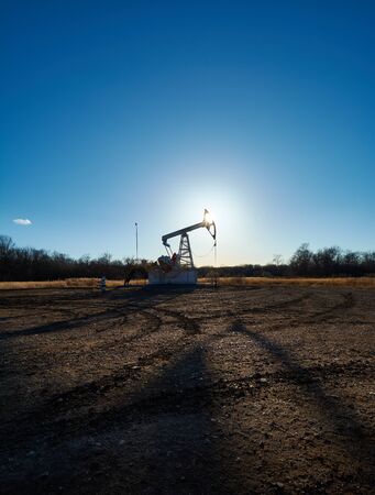 Oil rig in the field at sunsetの写真素材