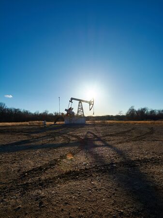 Oil rig in the field at sunsetの写真素材