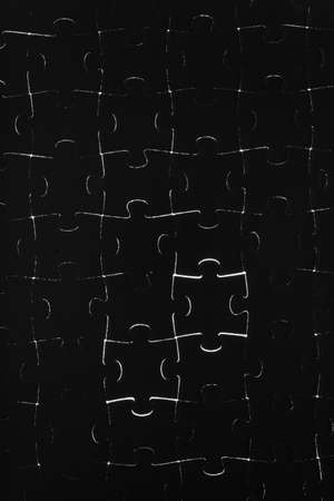 Black puzzle laid out on a white backgroundの写真素材