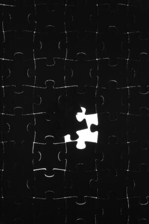 Black puzzle laid out on a white backgroundの写真素材