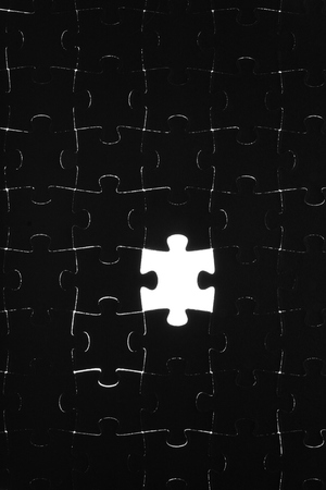 Black puzzle laid out on a white backgroundの写真素材