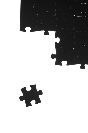 Black puzzle laid out on a white backgroundの写真素材