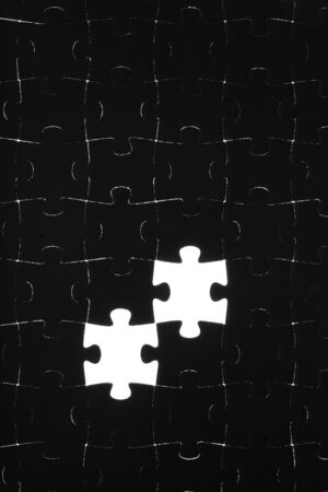 Black puzzle laid out on a white backgroundの写真素材