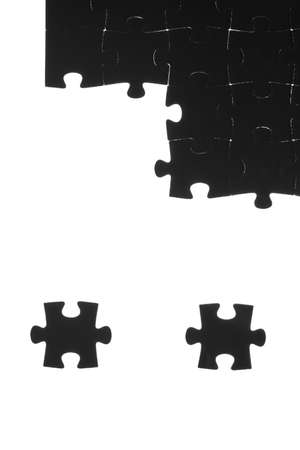 Black puzzle laid out on a white backgroundの写真素材