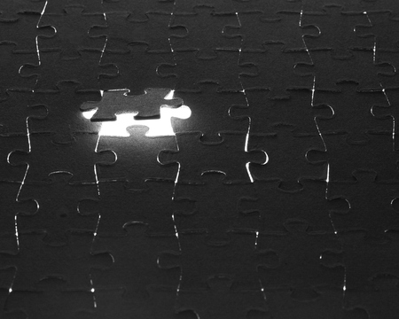 Black puzzle laid out on a white backgroundの写真素材