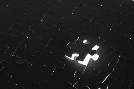 Black puzzle laid out on a white backgroundの写真素材